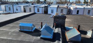 Roof view featuring multiple skylights and a chimney, showcasing roofing materials relevant to residential services in Philadelphia.
