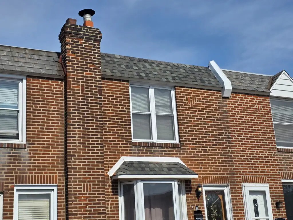 Brick row home with completed asphalt shingle roof and chimney — Discounted Roofing LLC Philadelphia