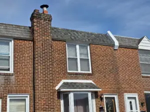 Brick row home with completed asphalt shingle roof and chimney — Discounted Roofing LLC Philadelphia