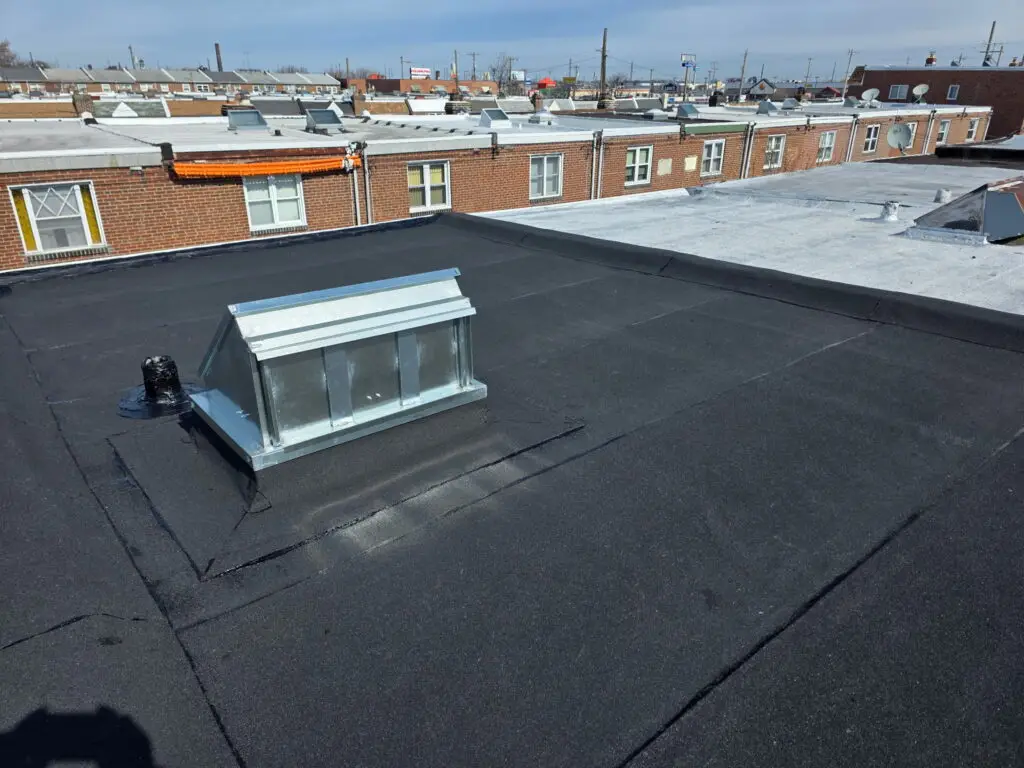 Flat rubber roof skylight cap, rooftop view of Philadelphia row homes — Discounted Roofing LLC