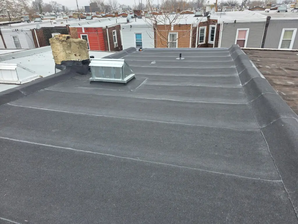 Flat rubber roof on urban Philadelphia row home with skylight and chimney — Discounted Roofing LLC